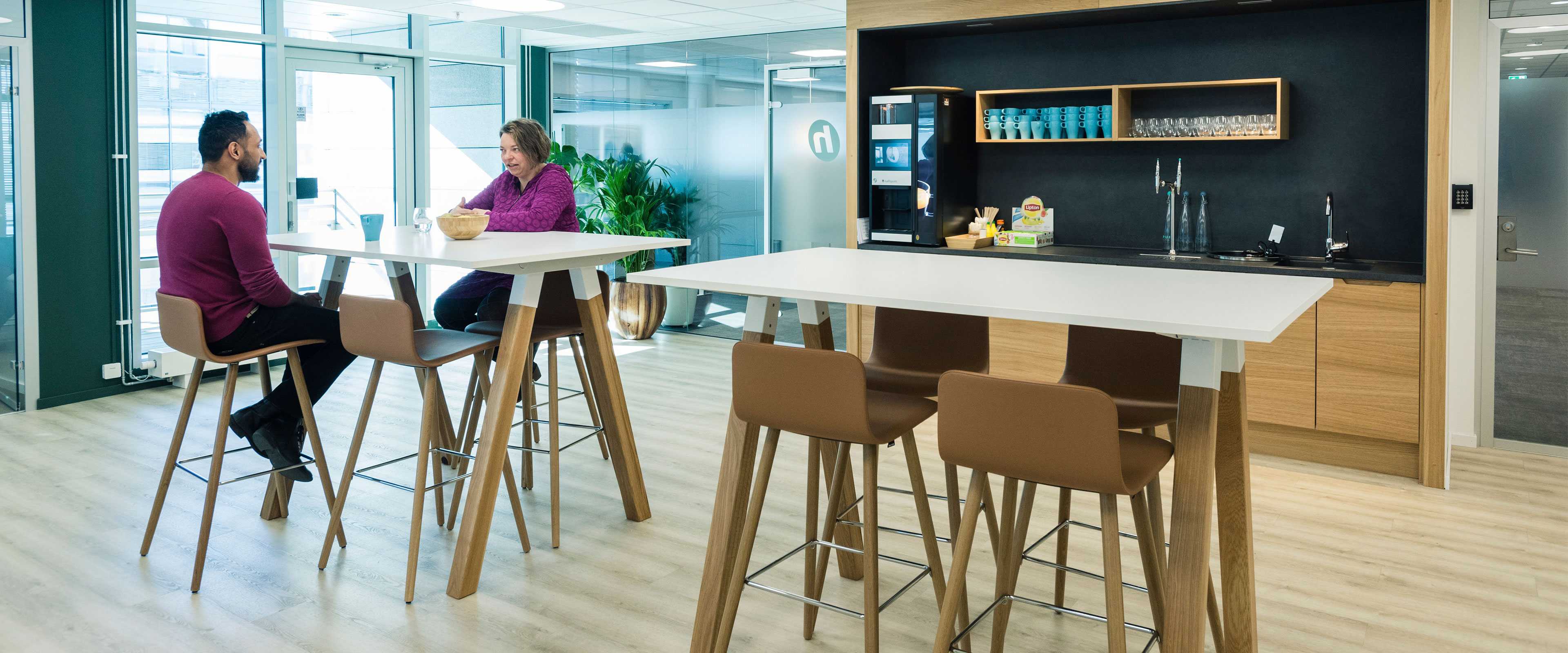 People sitting at Martela's Sola chairs and Frankie table in Holte Consulting's office