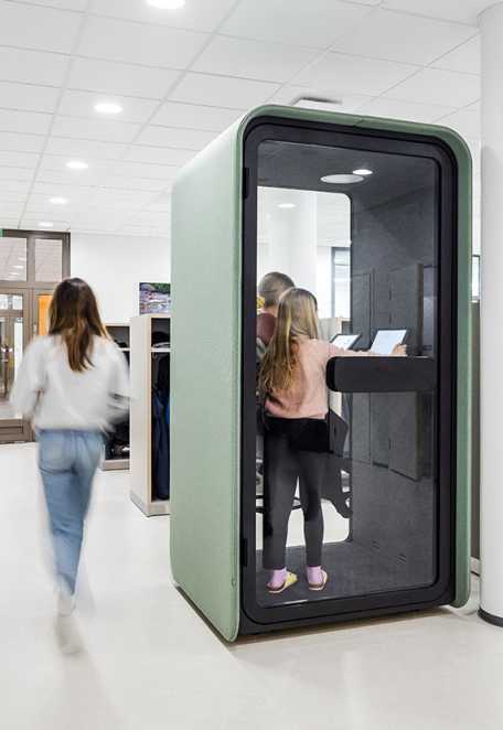Kaksi oppilasta opiskelemassa PodBooth-puhelinkopissa